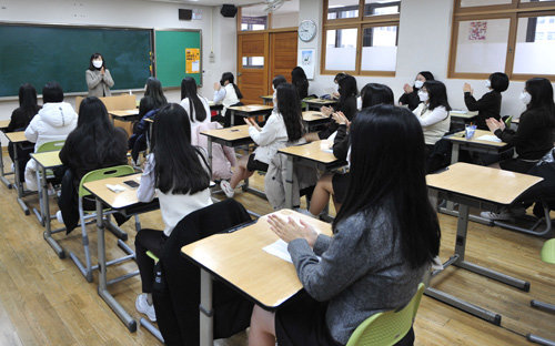 지난해 12월 23일 서울 동대문구 해성여고 학생들이 대학수학능력시험 성적표를 받고 서로에게 격려의 박수를 치고있는 모습. 사진공동취재단