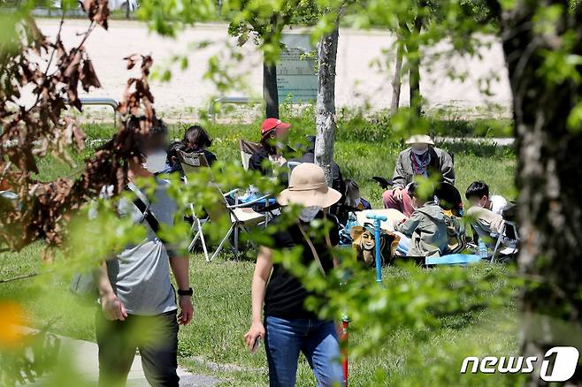 서울 여의도 한강공원 나들이에 나선 시민들이 돗자리에 앉아 음식을 먹고 있다. /뉴스1 © News1