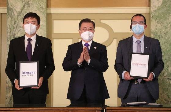 22일 오전(현지시간) 워싱턴에서 열린 '한미 백신 기업 파트너십 행사.' 문재인 대통령(가운데)이 참석한 가운데 존 림 삼성바이오로직스 대표(왼쪽)와 스테판 반셀 모더나 최고경영자(오른쪽)가 백신 위탁 생산 계약을 체결했다. [연합뉴스]