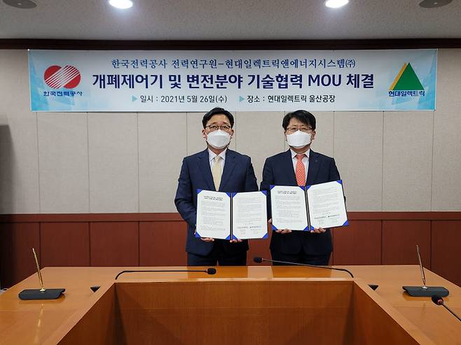 한국전력 전력연구원과 현대일렉트릭앤에너지시스템은 26일 현대일렉트릭 울산 공장에서 변전 분야 공동연구 및 개발 분야 협력 확대를 위한 공동연구 협력을 위한 양해각서(MOU)를 교환했다. 강지원 한전 전력연구원 차세대송변전연구소장(왼쪽)과 이준엽 현대일렉트릭앤에너지시스템 최고기술책임자(CTO)(오른쪽)가 협약서를 들어보이고 있다.