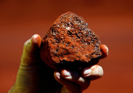 한 호주 광부가 서호주 필버라 지역 광산에서 채굴한 철광석을 들어 보이고 있다. [로이터=연합뉴스]
