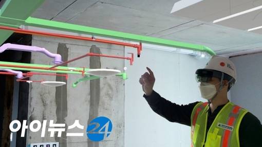 AR웨어러블 기기를 착용하고 시공 위치와 작업 환경을 확인하는 근로자 [사진=현대건설]