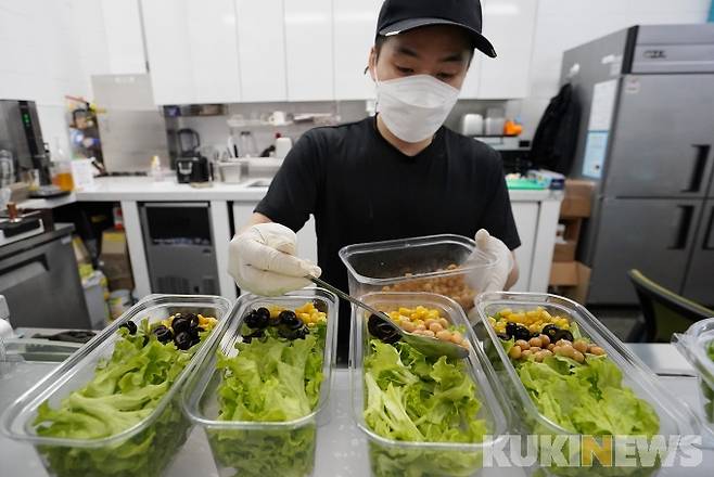 상도역 팜카페에서 한 종업원이 수확된 채소들로 샐러드를 만들고 있다.&nbsp;