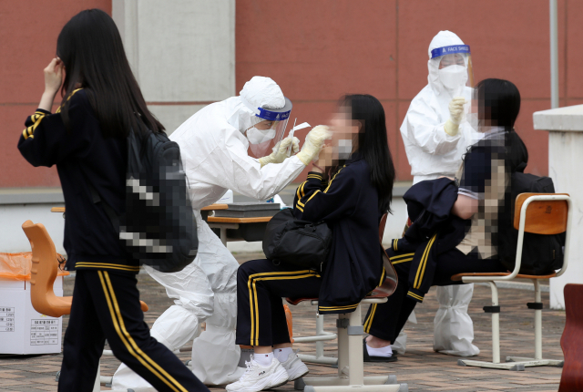 광주 북구 한 고등학교에 설치된 임시 선별진료소에서 학생들이 코로나19 검사를 받고 있다. 연합뉴스 제공