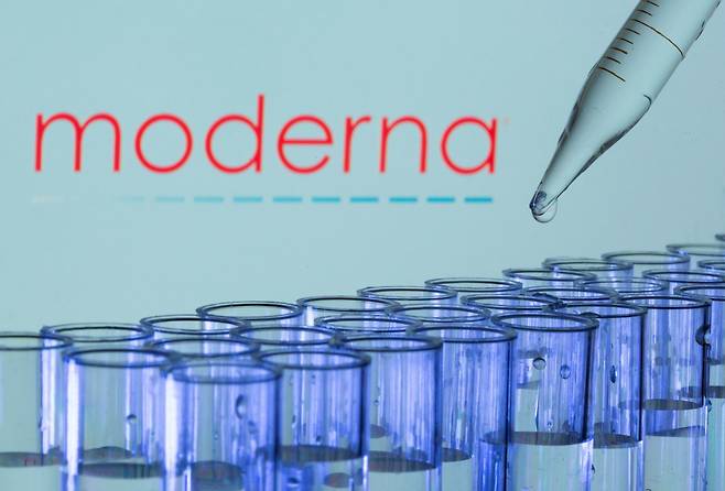 Test tubes are seen in front of a displayed Moderna logo. (Reuters-Yonhap)
