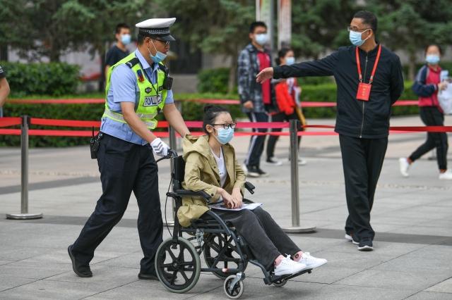 중국 네이멍구 후허하오터의 한 고등학교에서 7일 경찰관이 휠체어를 탄 수험생을 도와 시험장에 들어갔다. 신화통신뉴시스
