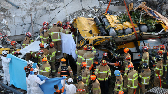 9일 오후 광주 동구 학동의 한 철거 작업 중이던 건물이 붕괴, 도로 위로 건물 잔해가 쏟아져 시내버스 등이 매몰됐다. 사진은 사고 현장에서 119 구조대원들이 구조 작업을 펼치는 모습.  연합뉴스