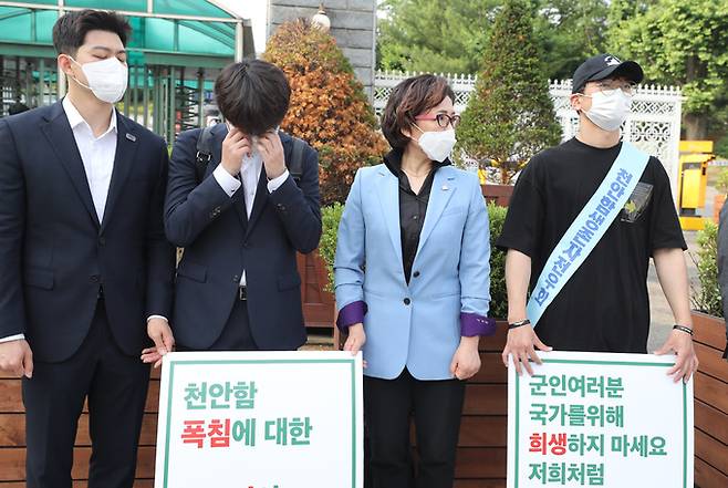 국민의힘 이준석 당대표 후보가 9일 서울시 용산구 국방부 앞에서 시위를 벌이고 있는 천안함 희생자 유가족을 방문, 시위에 동참하며 유가족과 대화를 나누다 눈물을 닦고 있다. 연합뉴스