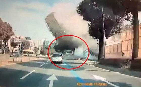 건물이 무너지면서 버스를 덮치는 사고 순간 모습. [뉴시스]