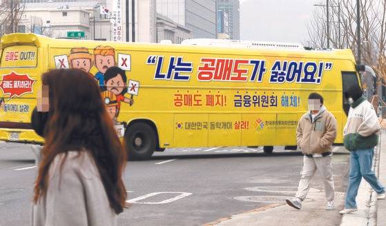 개인투자자 모임인 한국주식투자연합회(한투연)가 지난 2월 서울 세종로에서 공매도 반대 운동을 위해 '공매도 폐지' 등의 문구를 부착한 버스를 운행하고 있다. 연합뉴스