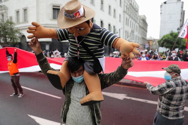 9일(현지시간) 페루 수도 리마에서 ‘좌파’ 자유페루당의 대선 후보 페드로 카스티요 지지자가 그의 승리를 자축하고 있다.   리마｜로이터연합뉴스
