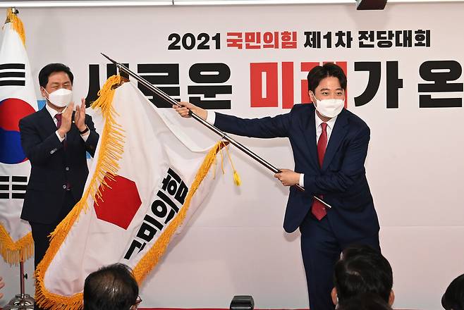 국민의힘 이준석 새 대표가 11일 서울 여의도 중앙당사에서 열린 전당대회에서 당기를 흔들고 있다. 사진공동취재단