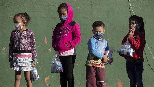 백신 집단면역, 성인 접종만으로도 가능할까 - 브라질 상파울로 시내에서 아이들이 마스크와 위생용품을 들고 밖에 나와있는 모습.네이처 제공