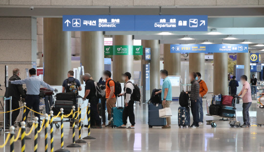 지난달 26일 영종도 인천국제공항 1터미널 해외입국자들이 전용버스 대기장소로 향하고 있다. 연합뉴스