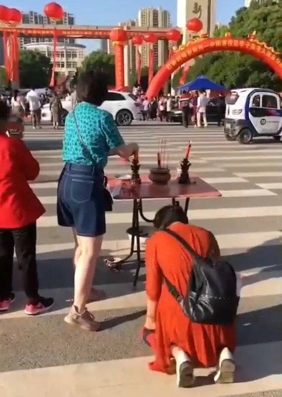 중국의 한 학부모가 후베이성 우한의 한 '가오카오' 수험장 앞에 제단을 차려놓고 향불을 피우며 자녀의 선전을 기원하고 있다. [중국 텅쉰망 캡처]