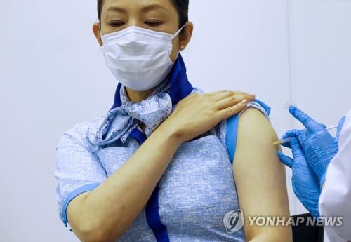 일본 기업까지 나서 백신 접종 (도쿄 로이터=연합뉴스) 13일 일본 도쿄도(東京都) 하네다(羽田)공항에 있는 전일본공수(ANA) 사무실에서 ANA 승무원이 신종 코로나바이러스 감염증(코로나19) 백신을 맞고 있다.