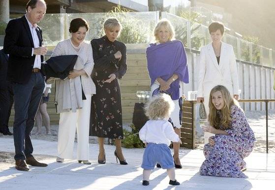 G7 참가국 정상 배우자들이 보리스 존슨 영국 총리의 아들을 흐뭇한 표정으로 바라보고 있다. (왼쪽부터) 하이콘 폰 데어라이엔 EU 집행위원장 남편, 김정숙 여사, 브리지트 마크롱 여사, 질 바이든 미국 영부인, 아멜리 데르보드랑기앵 EU 이사회 상임의장 부인, 캐리 존슨 영국 총리 부인. [영국 총리실]