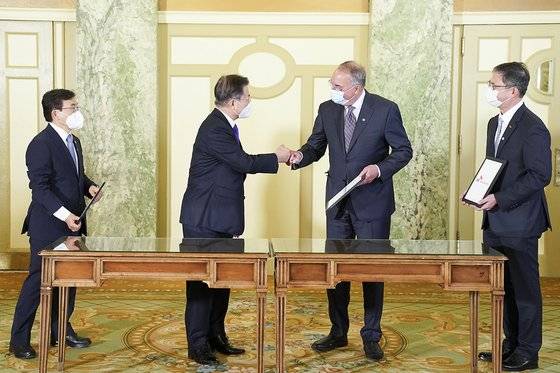 문재인 대통령이 5월 22일 오전(현지시간) 워싱턴 한 호텔에서 열린 '한미 백신 기업 파트너십 행사'에서 백신 연구 개발 협력 MOU을 체결한 스탠리 어크 노바백스 CEO와 인사하고 있다. 왼쪽은 권덕철 보건복지부 장관, 오른쪽은 안재용 SK바이오사이언스 대표. 사진 청와대, 뉴스1