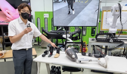 한국기계연구원 연구진이 새롭게 개발한 스마트 로봇의족에 대해 설명하고 있다. 사진제공=연합뉴스