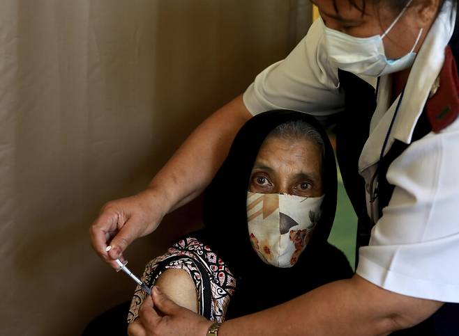 지난 5월26일 남아프리카공화국 케이프타운의 한 예방접종센터에서 백신을 접종받고 있는 76살 여성의 모습. 케이프타운/AP 연합뉴스