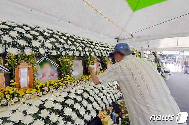 17일 오전 광주 동구청에 마련된 학동4구역 재개발 붕괴 참사 희생자 합동분향소에서 최연소 희생자 김군(18)의 아버지가 아들이 좋아했던 식료품을 나열하고 있다. 고교생 김군은 지난 9일 동아리모임을 위해 비대면수업인데도 학교를 찾았다가 '54번' 버스에 올라탄 뒤 끝내 돌아오지 못했다. 2021.6.17/뉴스1 © News1 정다움 기자