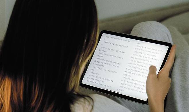 태블릿PC로 밀리의 서재가 서비스하는 전자책을 읽는 독자. 책을 선택할 때 ‘완독 지수’를 통해 다른 사람들은 얼마만큼 책을 읽다 덮었는지, 끝까지 읽는 데 시간이 얼마나 걸릴지 확인할 수 있다. /밀리의 서재