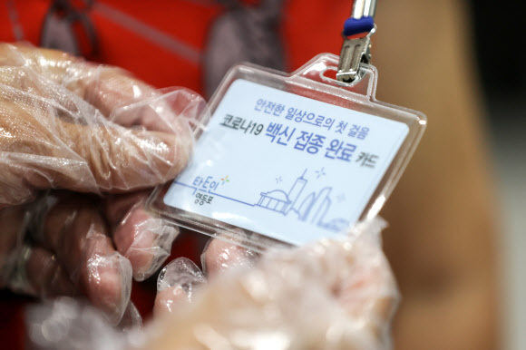 17일 오전 서울 영등포구 영등포아트홀에 마련된 코로나19 예방접종센터에서 한 어르신이 백신 접종 완료 카드를 보고 있다. 연합뉴스
