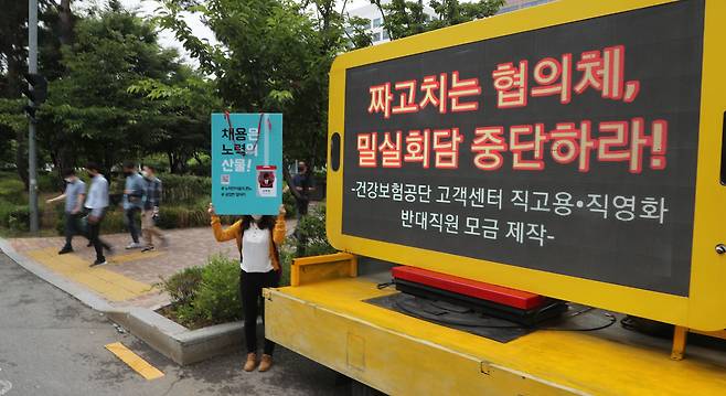 18일 오후 '사무논의협의회가' 열리고 있는 서울 여의도의 한 호텔 앞에서 국민건강보험공단 정규직 직원이 1인 시위를 하고 있다. 직원들은 돈을 모아 시위용 노란색 트럭을 빌렸다.  / 오종찬 기자