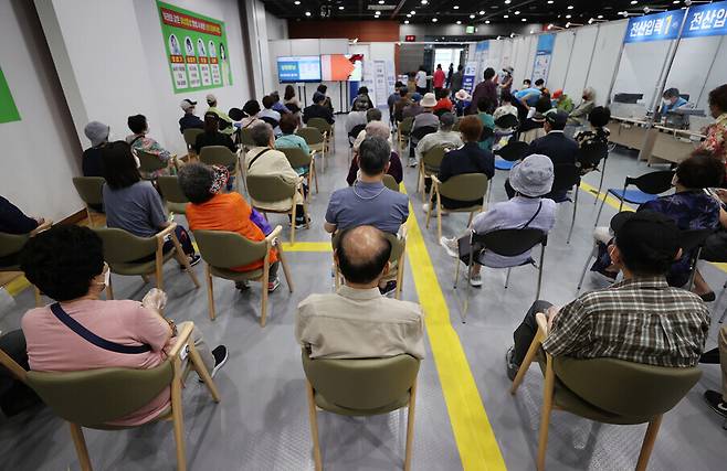 People who were administered a dose of COVID-19 vaccine Thursday wait at a vaccination center in Seoul to receive a vaccine certificate and be monitored for any adverse reactions. (Yonhap News)