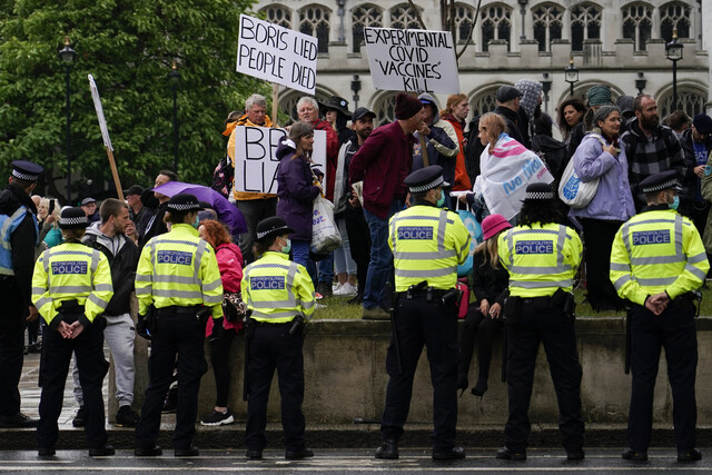 델타 변이 바이러스 확산으로 코로나19 관련 제한 조치 완화가 연기된 데 항의하는 시위대가 21일 런던 영국 국회의사당 앞에서 시위를 하고 있다. 런던/AP 연합뉴스