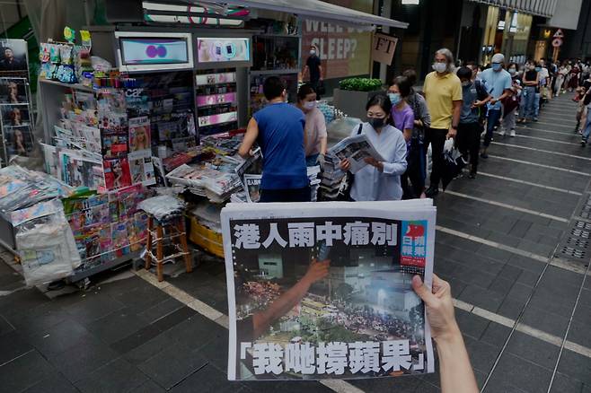 24일 홍콩 시민들이 24일자로 폐간하는 홍콩 신문 빈과일보의 마지막 호를 줄을 서서 사고 있다. /AP 연합뉴스