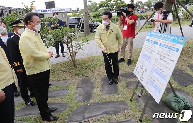 (제주=뉴스1) 오현지 기자 = 김부겸 국무총리가 25일 오후 제주국제공항 도보이동형 선별진료소를 찾아 임태봉 제주코로나방역대응추진단장으로부터 검체 채취 과정에 대한 설명을 듣고 있다. 2021.6.25/뉴스1