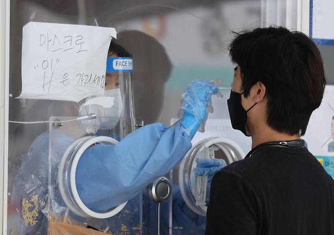 25일 오후 서울 중구 서울역 광장에 마련된 중구임시선별검사소에서 한 시민이 신종 코로나바이러스 감염증(코로나19) 선별검사를 받고 있다. [연합]