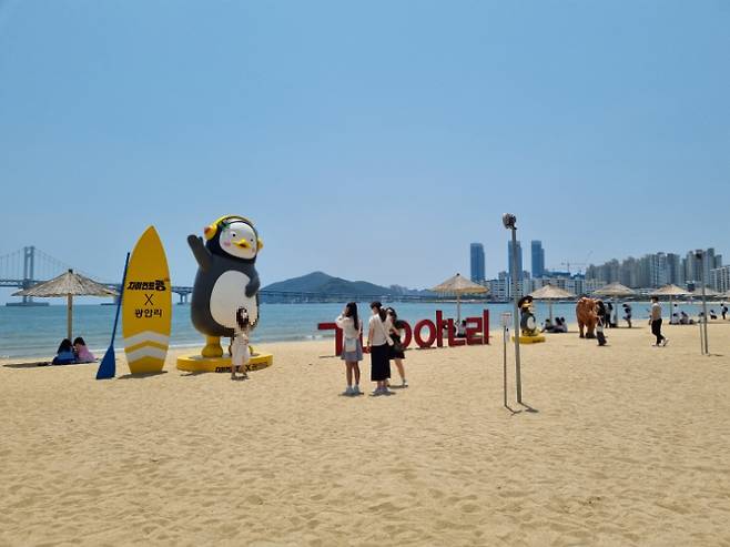 25일 부산 광안리해수욕장 해변에 설치된 '펭수' 조형물 앞에서 관광객들이 사진을 찍고 있다. 박진홍 기자