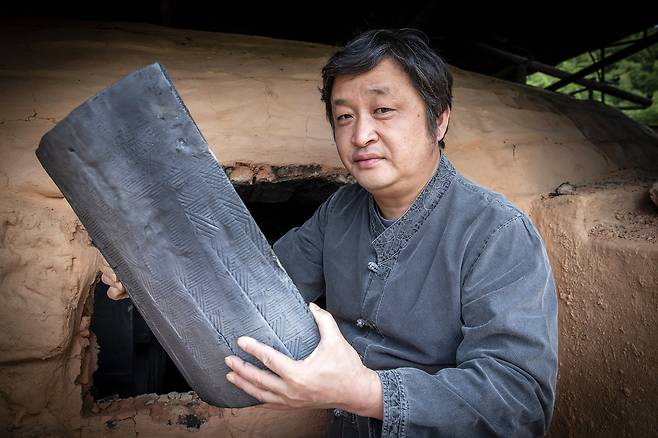 가마에서 꺼낸 기와를 살펴보고 있다.