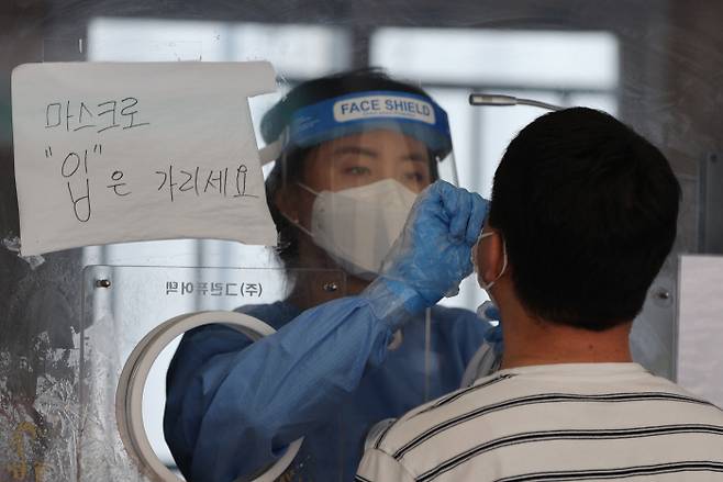 지난 25일 오후 서울 중구 서울역 광장에 마련된 임시선별검사소에서 한 시민이 코로나19 검사를 받고 있다. 연합뉴스