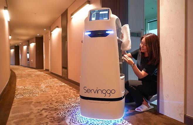 AI 로봇 ‘서빙고’가 호텔에서 룸서비스를 제공하고 있다. 서빙고는 투숙객이 주문한 음식과 물품을 전달하고 마스코트 역할도 한다.  SK텔레콤 제공