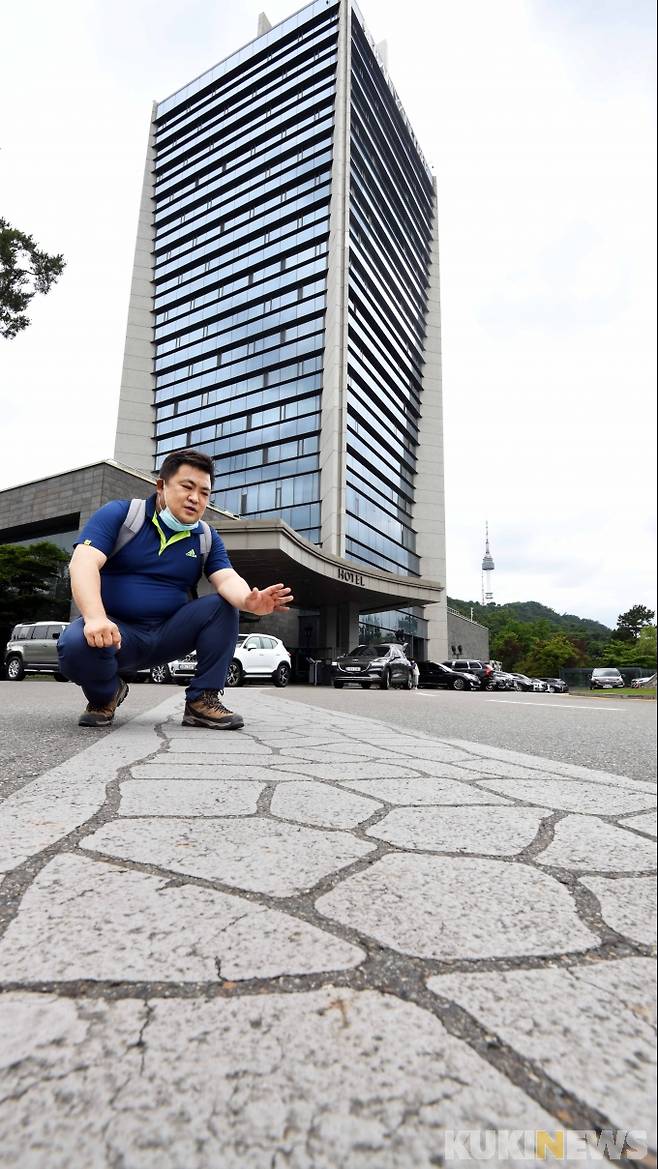 반얀트리호텔 앞 도로에서 '한양도성 흔적표시'에 대해 조치욱 서울역사박물관학예연구사가 설명하고 있다. “서울시는 4년여에 걸쳐 ‘한양도성 단절구간 흔적표시’ 사업을 진행했다”면서 “건물‧주택가로 사라진 구간 내 주요 갈림길에 바닥 흔적페인팅 총 8개소 235m, 바닥동판 총 300개소를 표시했다”고 설명한다.