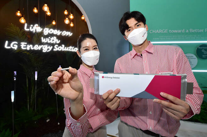LG에너지솔루션 관계자가 지난 9~11일 서울 삼성동 코엑스에서 열린 ‘인터배터리 2021’에서 초소형 원통형 배터리(왼쪽)와 파우치형 배터리인 롱셀을 들고 있다. (사진=LG에너지솔루션)