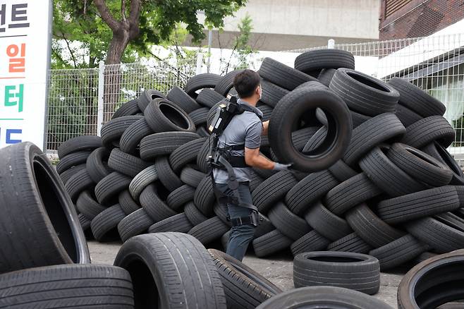 한국타이어 티스테이션 대전점 근로자가 근력지원을 받으며 타이어 적재 작업을 수행하고 있다.[한국생산기술연구원 제공]