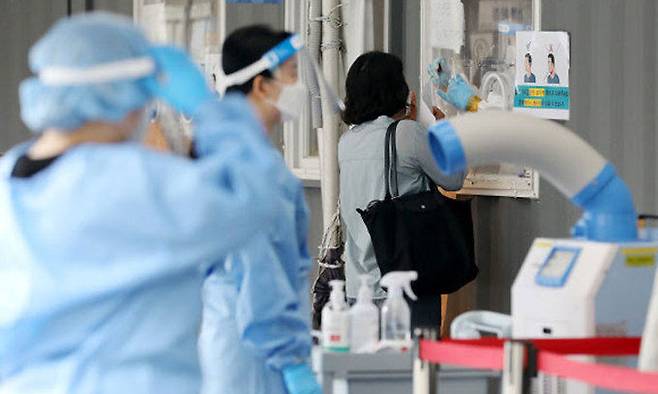 30일 오전 서울역에 마련된 중구임시선별진료소에서 의료진이 검체채취를 하고 있다. 뉴스1
