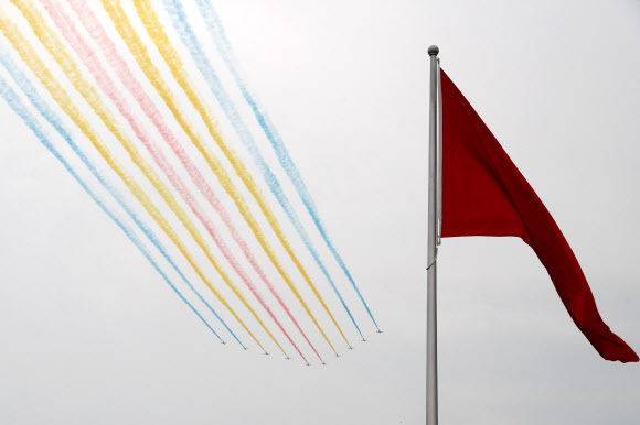 중국공산당 창당 100주년 기념일인 1일 수도 베이징의 톈안먼 광장에 나부끼는 대형 오성홍기 위로 전투기들이 오색 연기를 내뿜으며 날고 있다. 베이징 로이터=연합뉴스