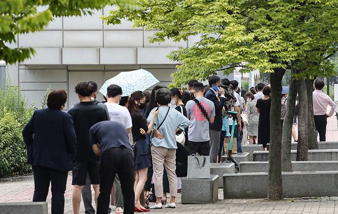 6일 오전 서울 마포구 서강대역 환승공영주차장 인근에 마련된 신종 코로나19 임시선별검사소에 진단 검사를 받으려는 시민들이 줄지어 서 있다.