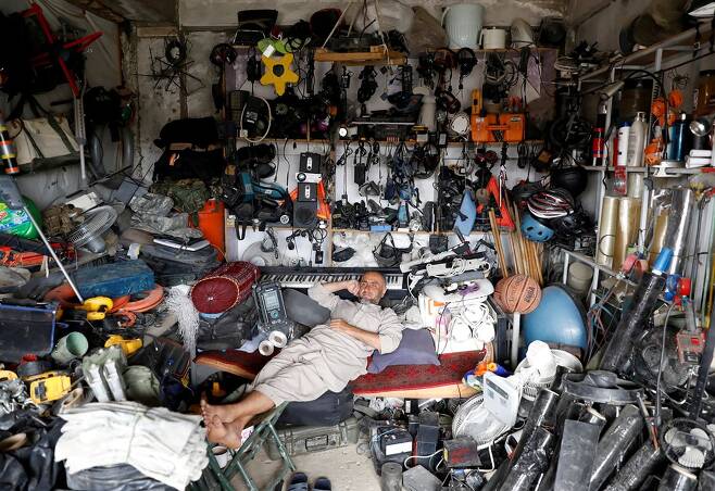 미 공군기지에서 나온 중고품을 파는 가게에서 휴식을 취하고 있는 아프칸 남성. 사진=로이터 연합뉴스