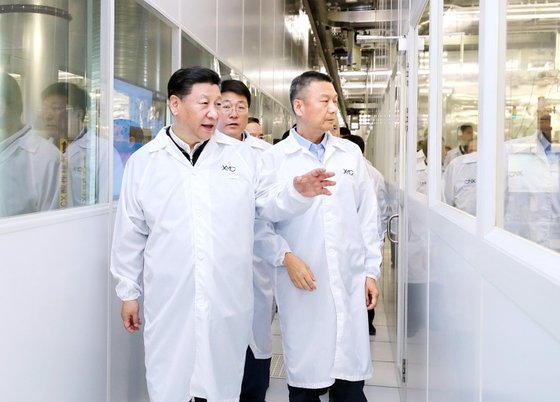 지난 2018년 4월 중국 우한에 있는 YMTC 공장에서 시진핑(왼쪽) 국가 주석이 자오웨이궈(가운데) 칭화유니그룹 회장, 양스닝(오른쪽) YMTC 최고경영자와 함께 반도체 생산 라인을 둘러보고 있다. [신화통신]