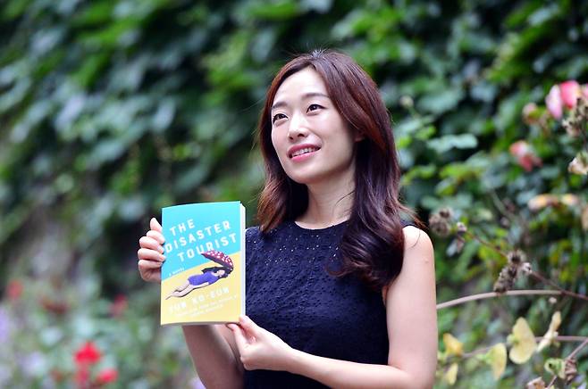 Yun Ko-eun poses with her book, “The Disaster Tourist,” during an interview with The Korea Herald on Wednesday. (Park Hyun-koo/The Korea Herald)