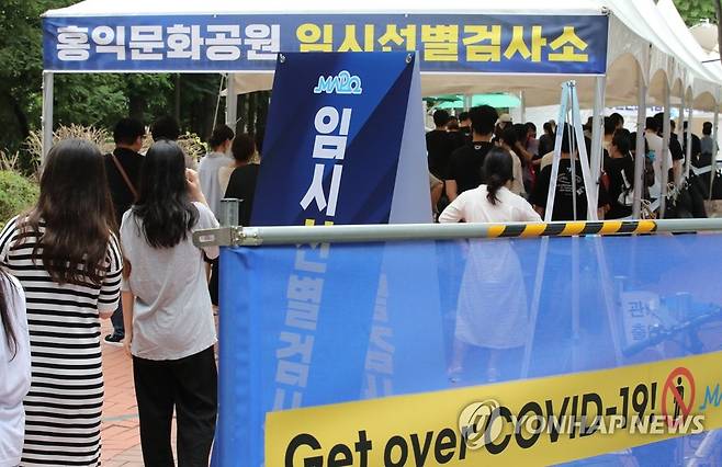 임시선별검사소에 줄지어 선 시민들 (서울=연합뉴스) 황광모 기자 = 신종 코로나바이러스 감염증(코로나19) 신규 확진자가 1주일째 1천 명 이상 기록 중인 13일 오후 서울 마포구 홍대 거리 내 홍익문화공원에 설치된 마포구 임시선별검사소에서 코로나19 검사를 받으려는 시민들이 더위 속에 대기하고 있다. 2021.7.13 hkmpooh@yna.co.kr