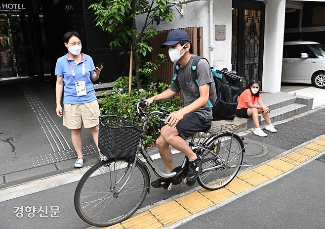 2020 도쿄올림픽 취재진이 13일 도쿄 분쿄구 미디어호텔 앞에서 우버이츠를 통해 음식을 배달받고 있다. 도쿄올림픽 조직위의 권고에 따라 일본에 입국하는 외국 취재진은 3일간 호텔 내에서 자가격리를 해야 한다. 자가격리 기간에는 편의점을 이용하거나 배달앱을 통해 배달음식으로 식사를 해결해야 한다.  2021.07.14 도쿄=올림픽사진공동취재단