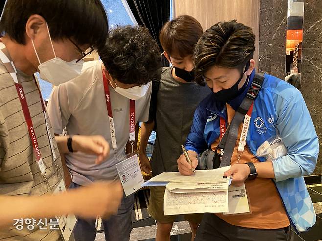 2020 도쿄올림픽 취재진이 13일 도쿄 분쿄구 미디어호텔  로비에서 대회 관계자에게 코로나19 검사 진단 키트를 전달하고 있다.  2021. 7. 14 도쿄=올림픽사진공동취재단