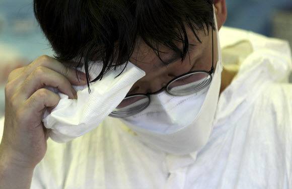 폭염이 이어지고 있는 15일 오후 서울 양천구 파리공원에 설치된 찾아가는 선별진료소에서 의료진이 땀을 닦고 있다. 뉴시스